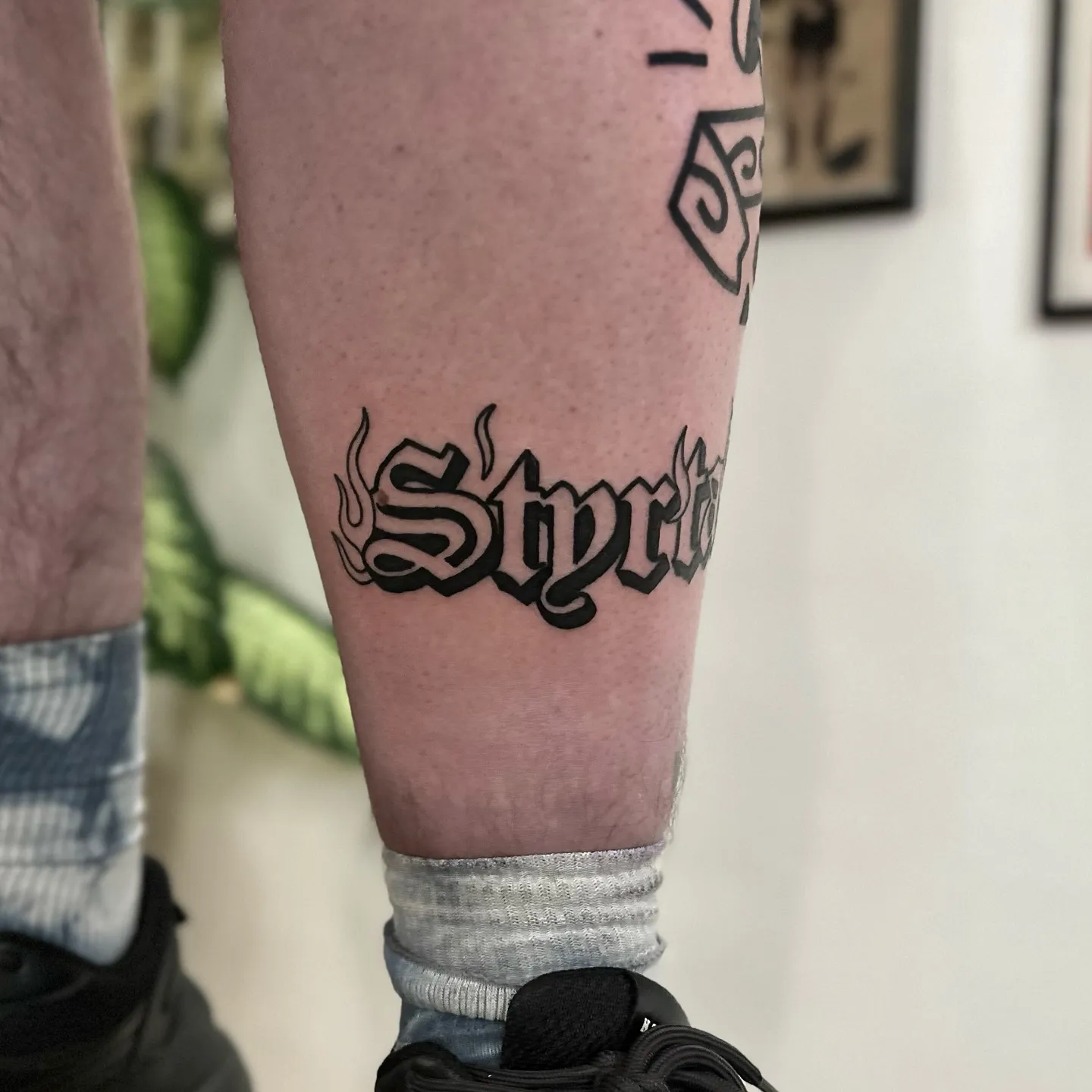 Tatuaż lettering z ultragrubym konturem na łydce — tatuaż, Wujek Darek, Warszawa, Polska