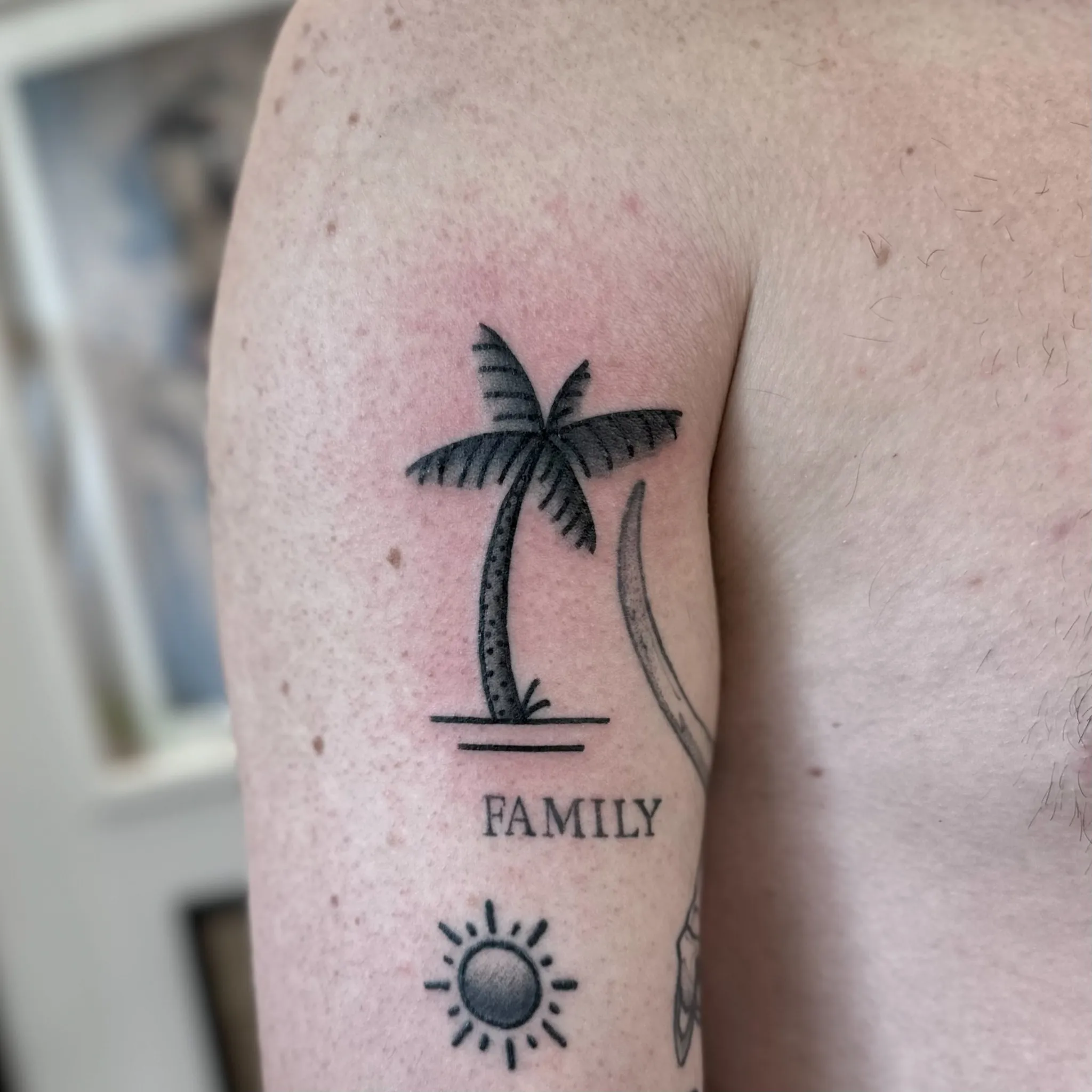 Tatuaż palmy z napisem Family i słońcem w grubym konturze — tatuaż, Wujek Darek, Warszawa, Polska