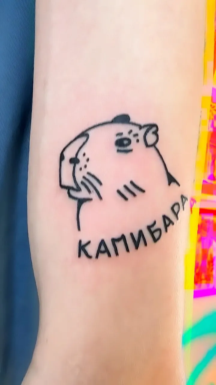 Ignorant tatuaż kapibary z letteringiem na przedramieniu — tatuaż, Wujek Darek, Warszawa, Polska