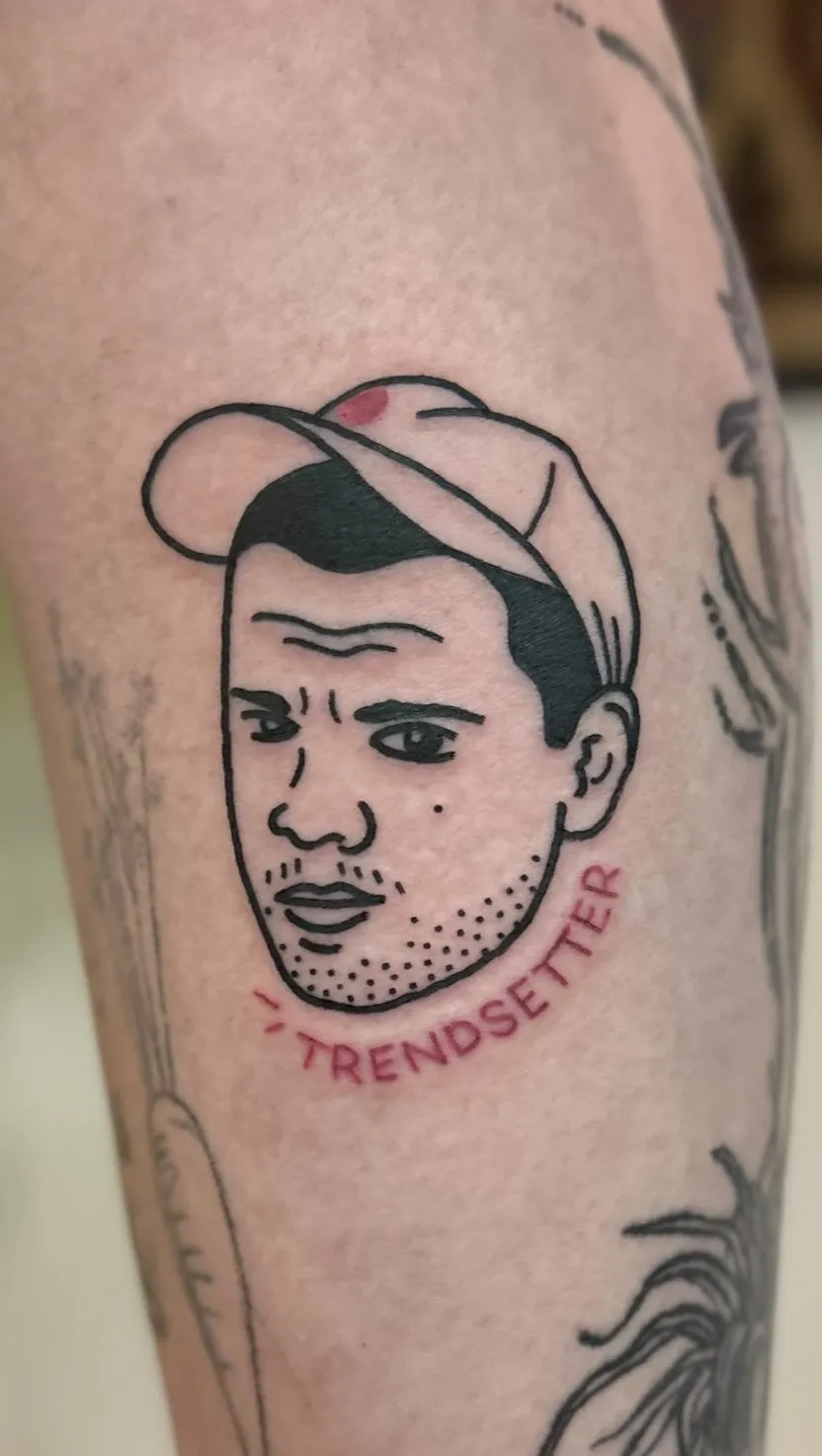 Ignorant tatuaż portret twarzy z napisem w półokręgu na nodze — tatuaż, Wujek Darek, Warszawa, Polska
