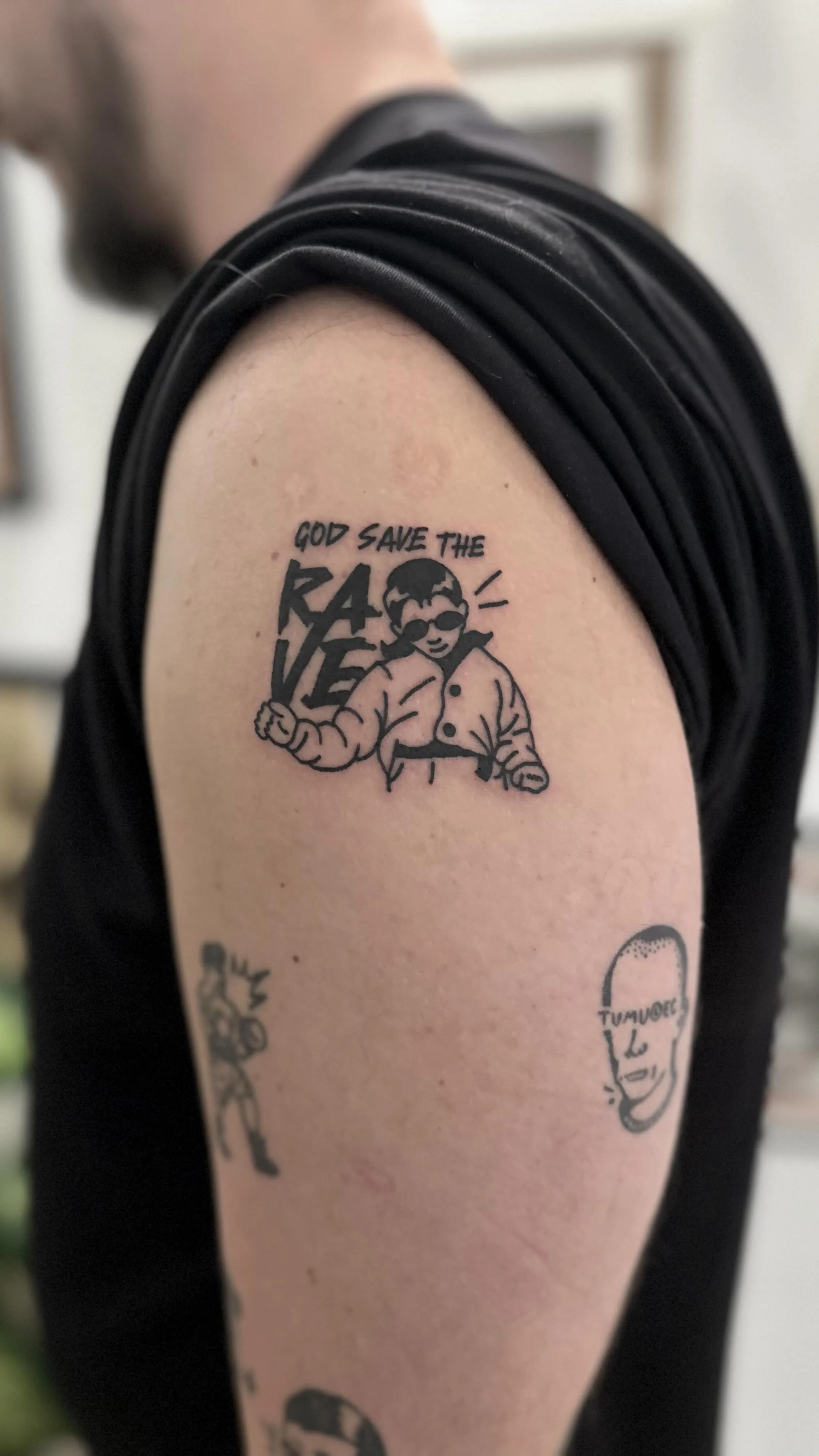 Tatuaż God Save the Rave z grubym konturem i lettering'iem — tatuaż, Wujek Darek, Warszawa, Polska