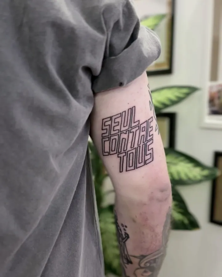 Tatuaż lettering ultragrubym konturem na ramieniu — tatuaż, Wujek Darek, Warszawa, Polska