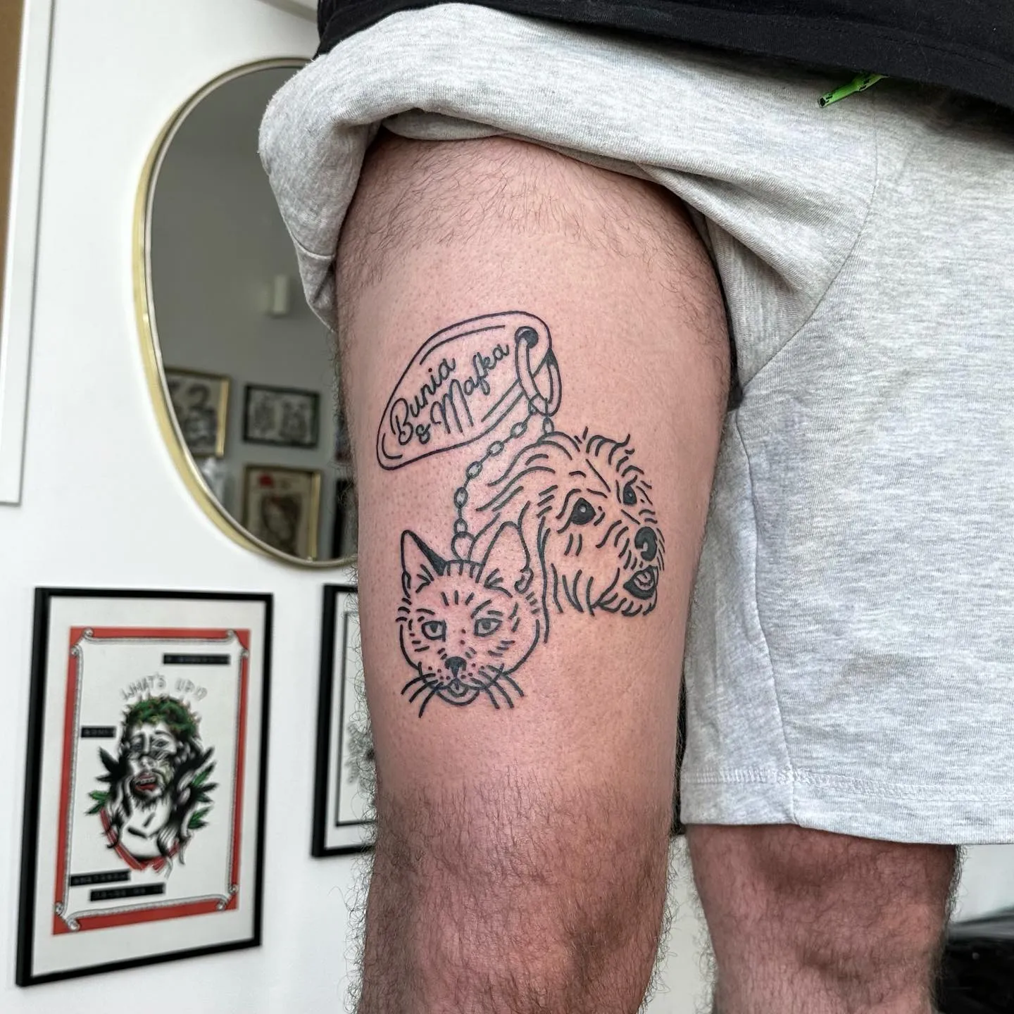 Tatuaż z głową psa i kota w grubym konturze z lettering'iem — tatuaż, Wujek Darek, Warszawa, Polska